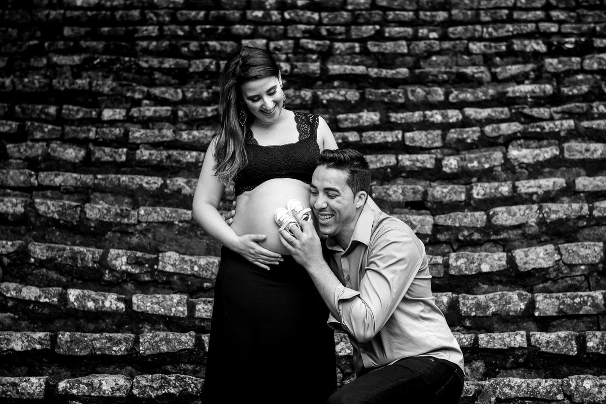 casal gestante abraçados e beijando a barriga no jardim botânico em são paulo